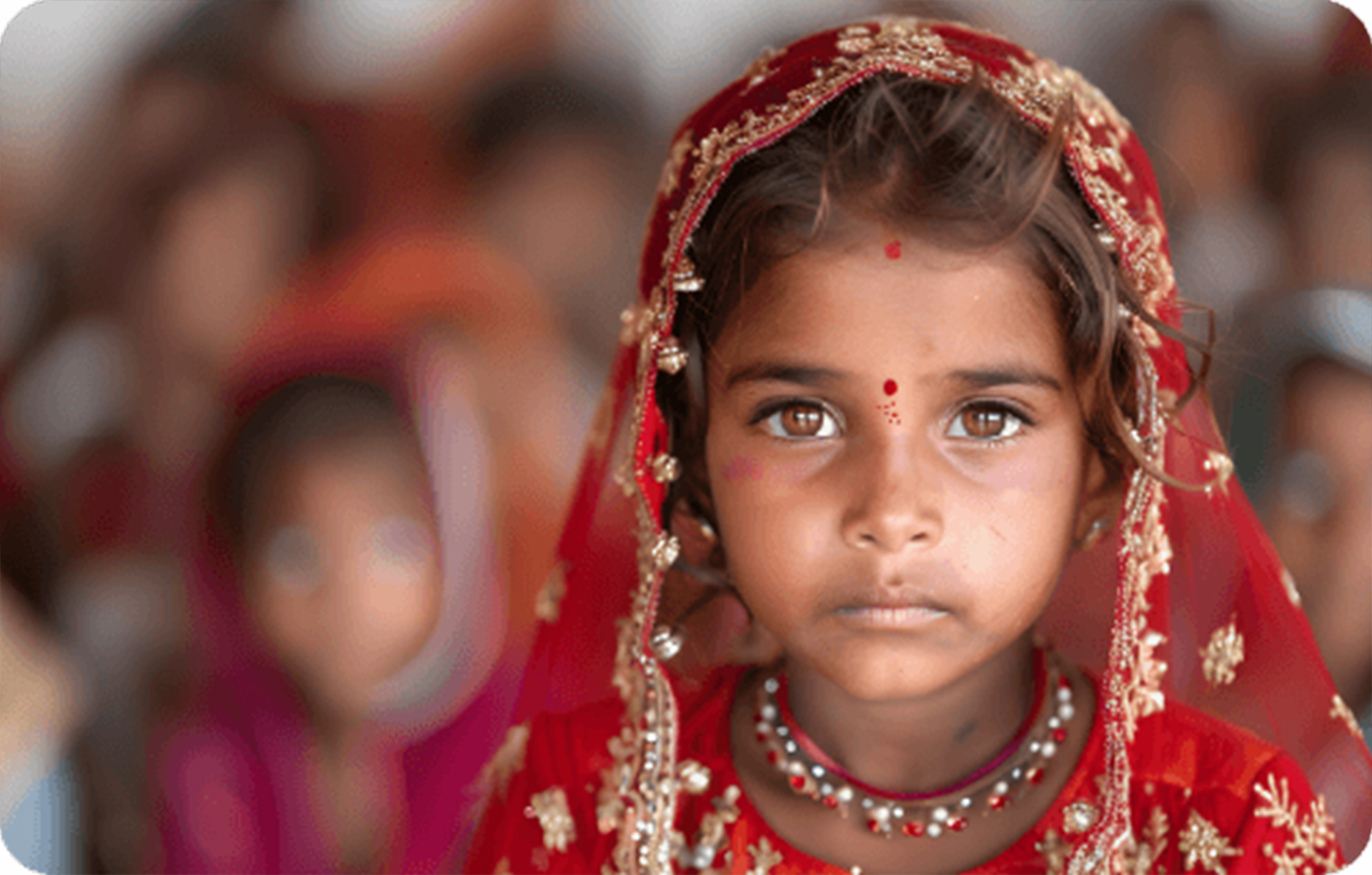 Portrait of a young Indian girl in a red headscarf.